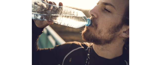An athlete drinks bottled water