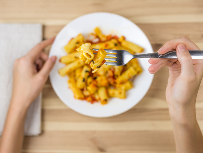 Girl eating pasta with fork