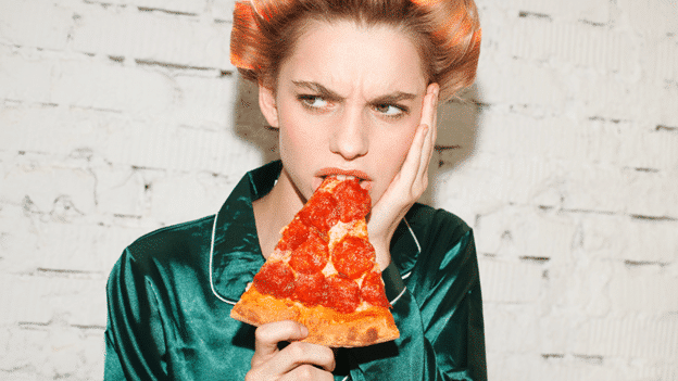 A woman eating a slice of pizza